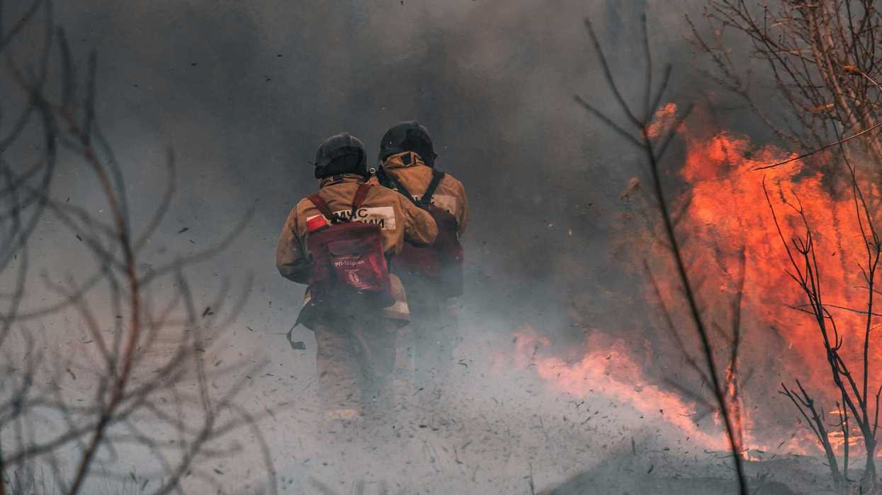 3 men in black jacket and black pants playing with fire.