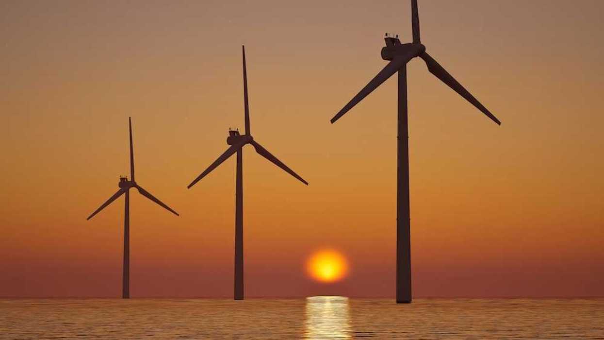3 offshore wind turbines sillouetted against a setting (or rising) sun