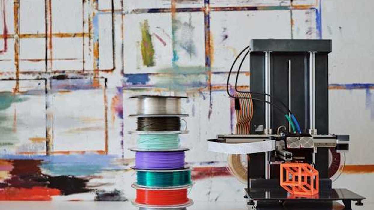 3D filament spools next to a 3d printing machine