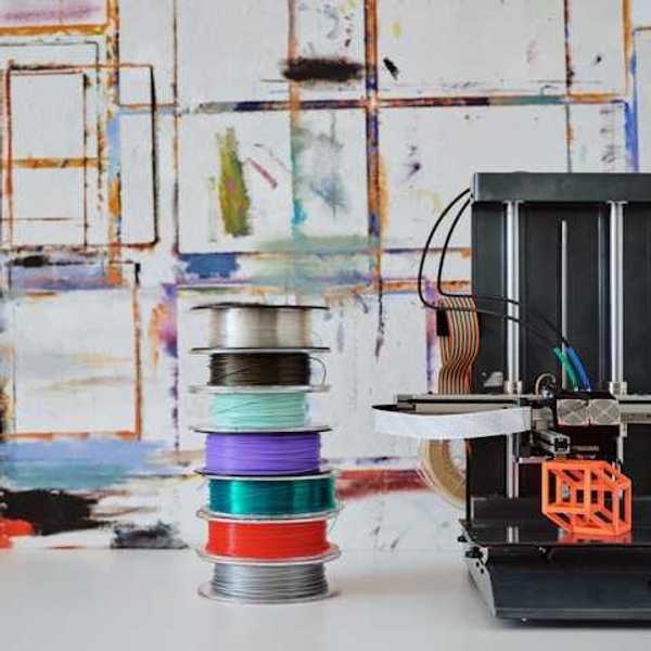 3D filament spools next to a 3d printing machine