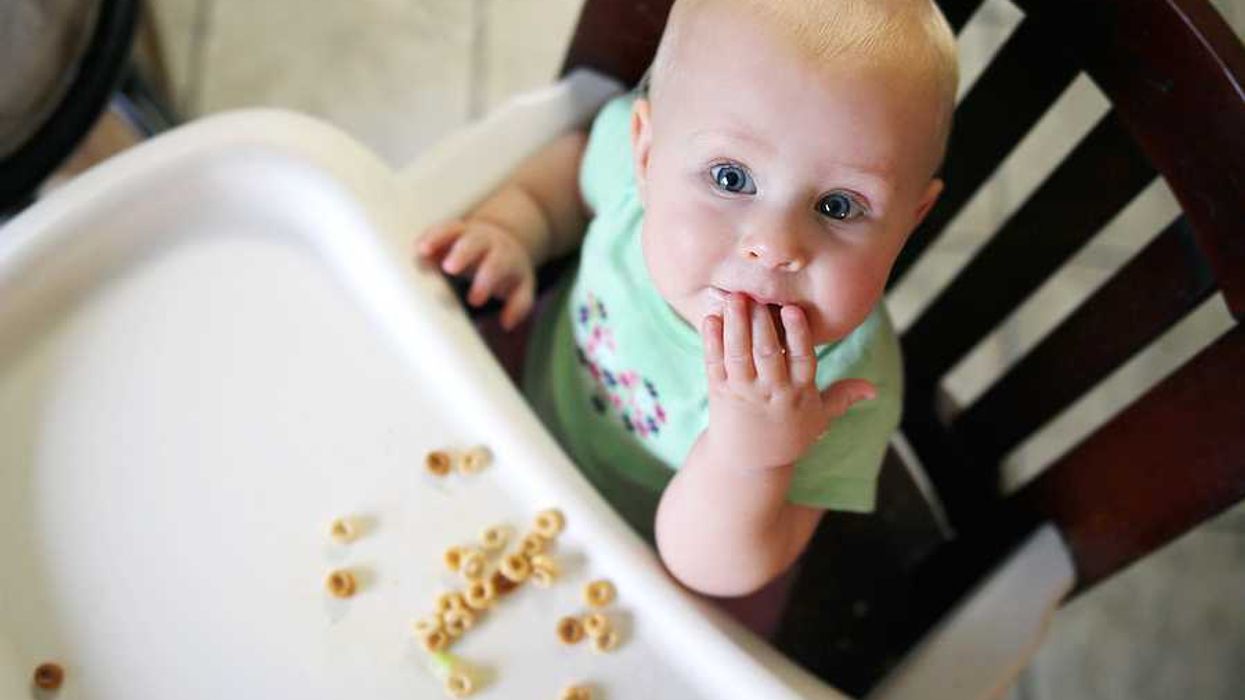 A baby eating cereal in a high chair