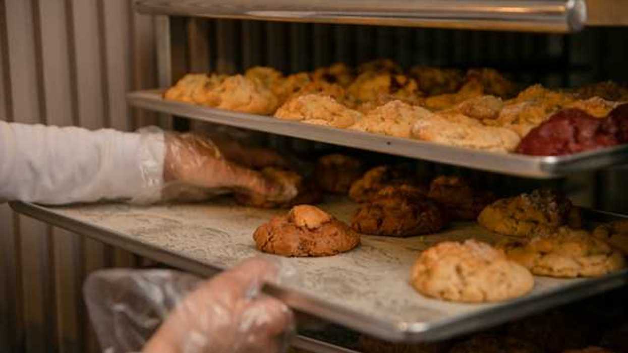 A baker placing baked goods on a tray