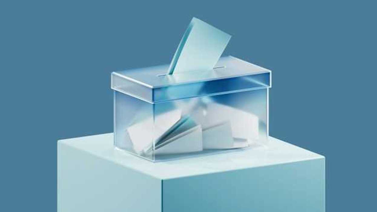 A ballot box with ballots in it against a blue background