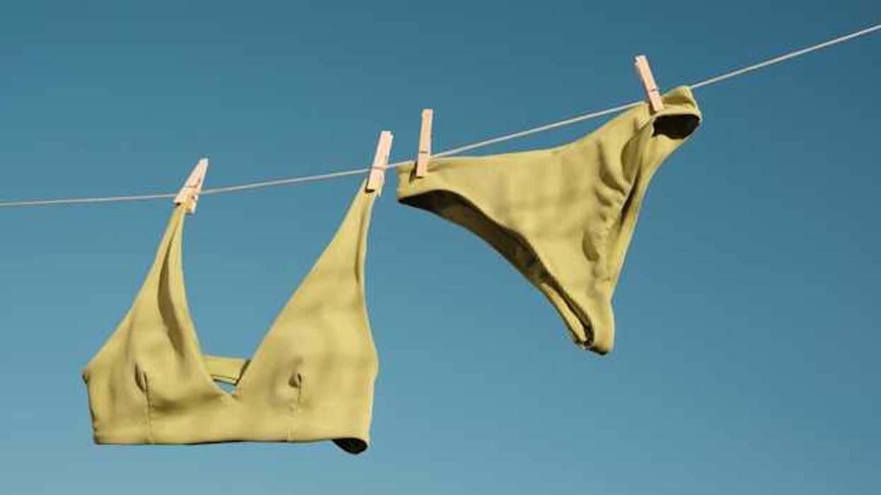 A bathing suit hanging on a line drying in the sun