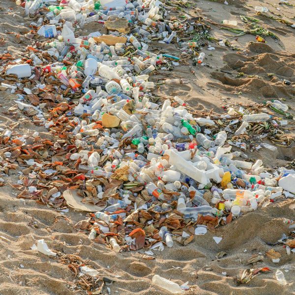A beach covered in piles of plastic bottles and debris