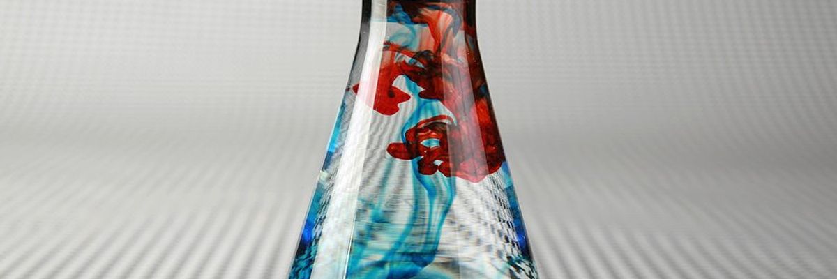 A beaker full of blue and red colored water.