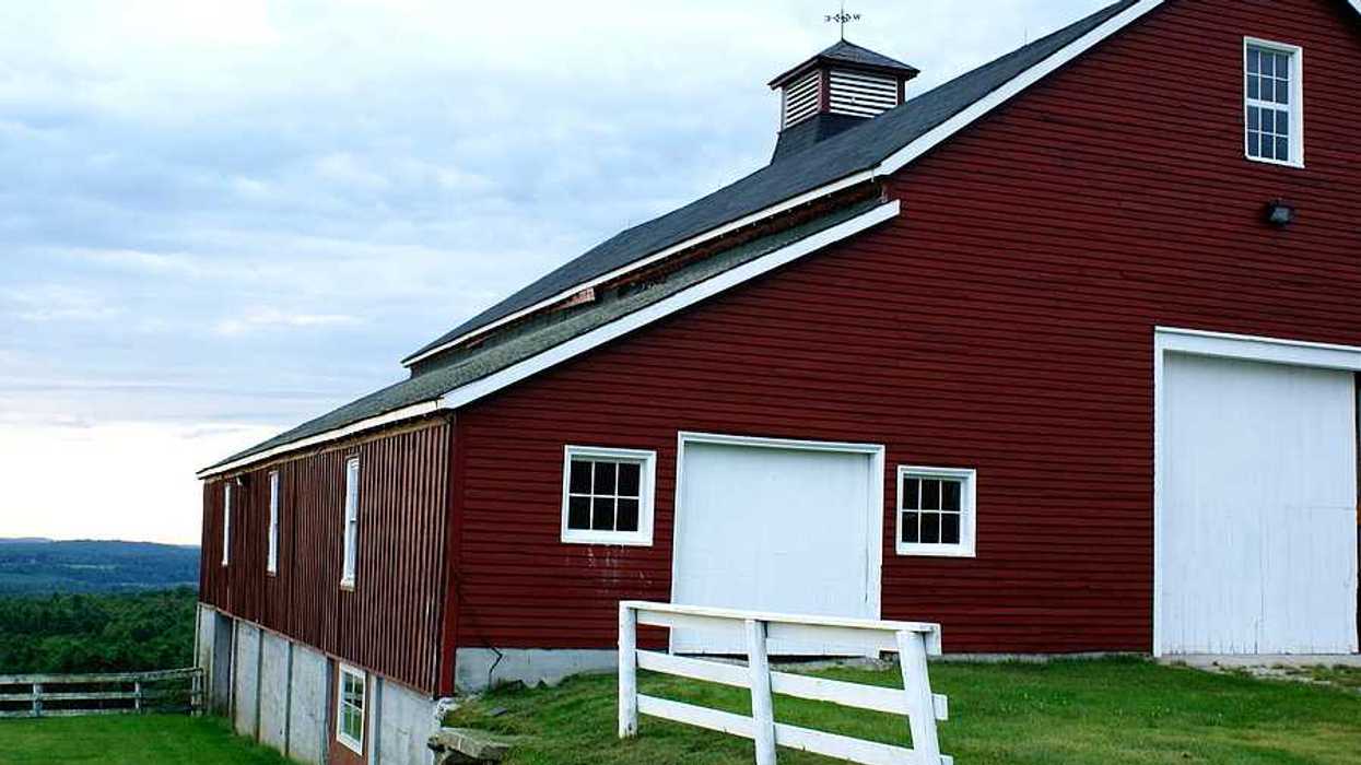 A big red barn overlooking a green valley