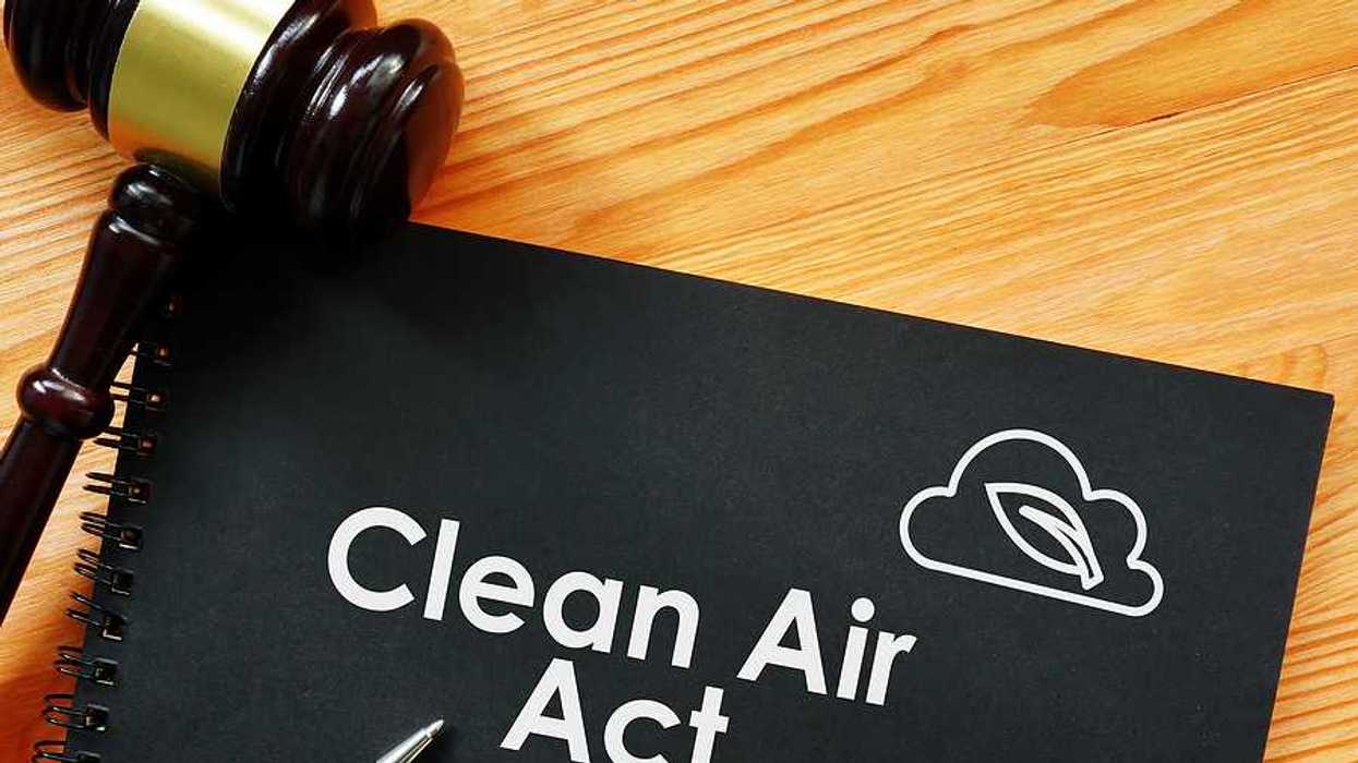 A binder with the words Clean Air Act with a wooden court gavel sitting next to it