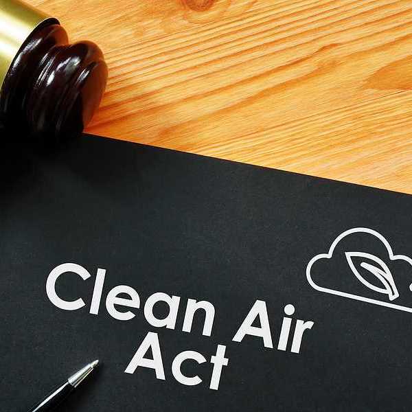 A binder with the words Clean Air Act with a wooden court gavel sitting next to it