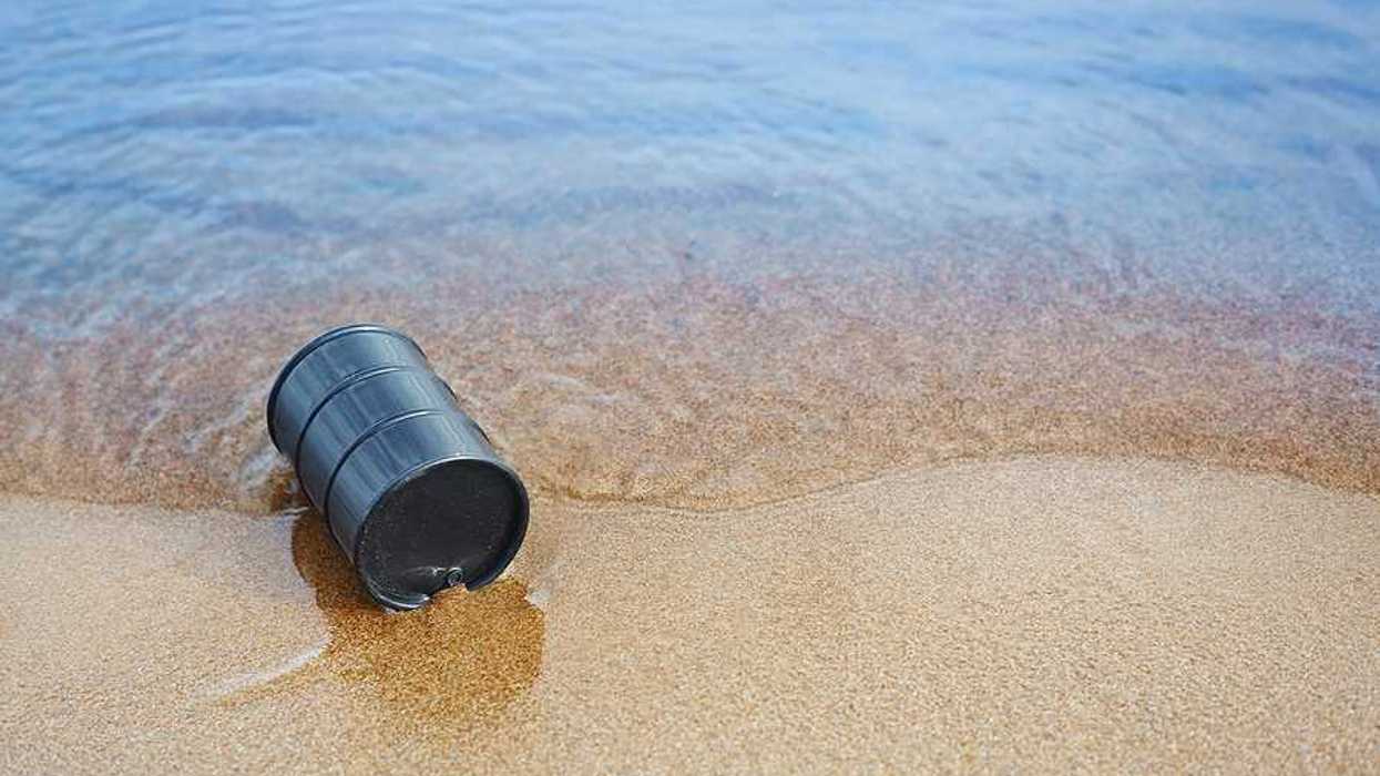 A black barrel washed up on a sandy beach
