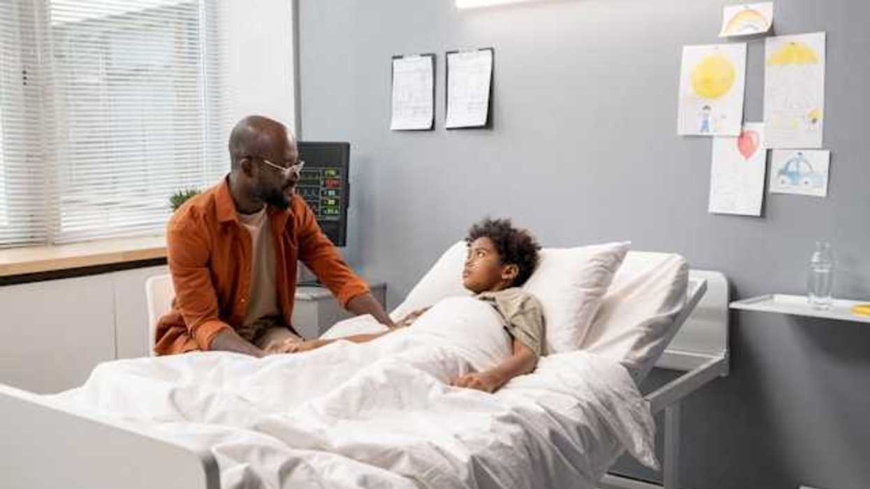 A Black man talking to his child in a hospital bed
