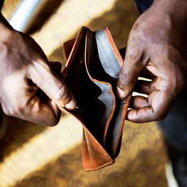 A Black person's hands holding an empty wallet