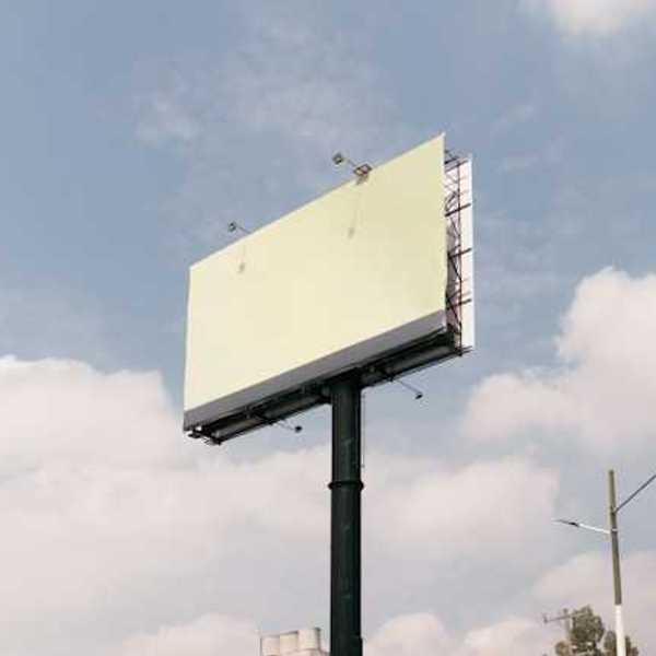 A blank billboard against a blue sky with clouds