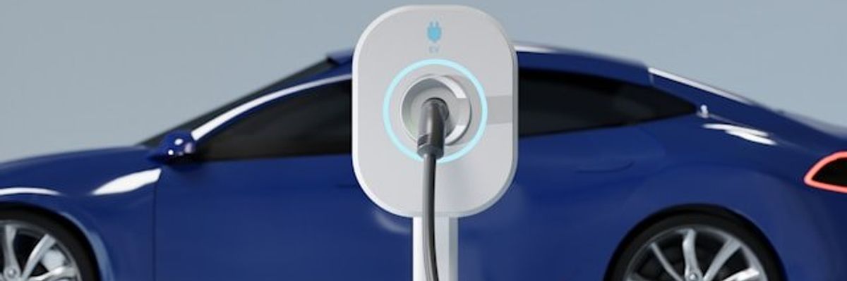 A blue electric vehicle being charged at an EV charging station.