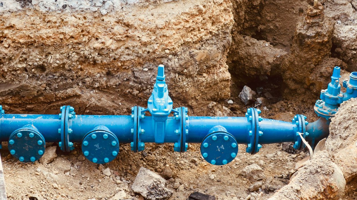 a blue water pipe in a dirt trench.