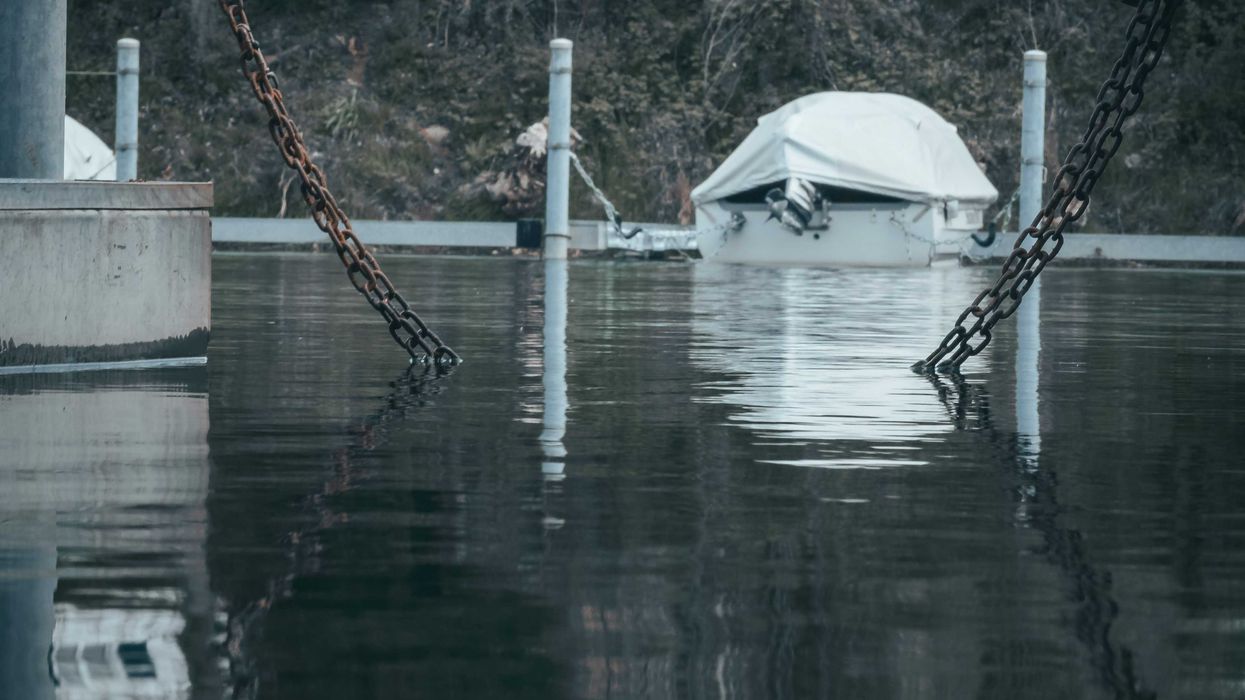 a boat tied to a dock in a flooded area.