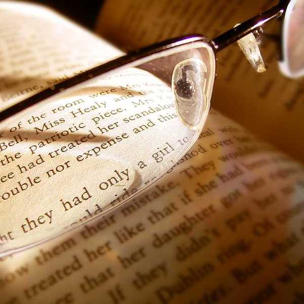 A book with reading glasses magnifying some of the text