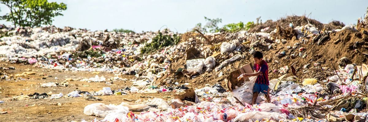 A boy surrounded by plastic waste