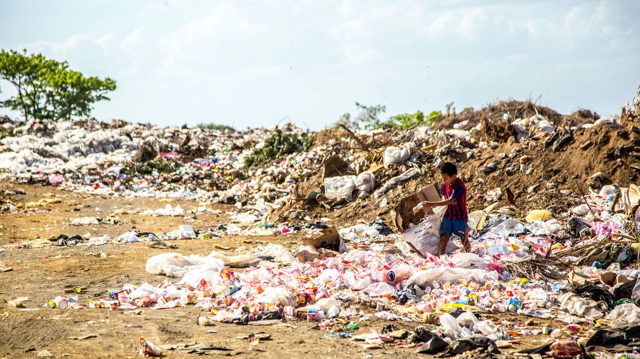 A boy surrounded by plastic waste