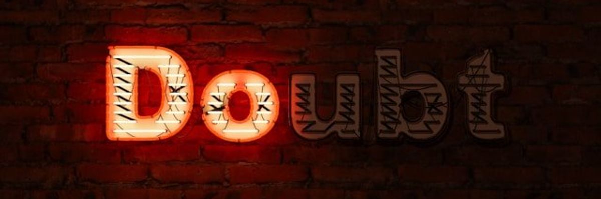 A brick wall with the word Doubt on it, with the D and the O illuminated in red.