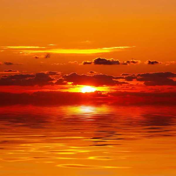 A bright red and orange sunset over water