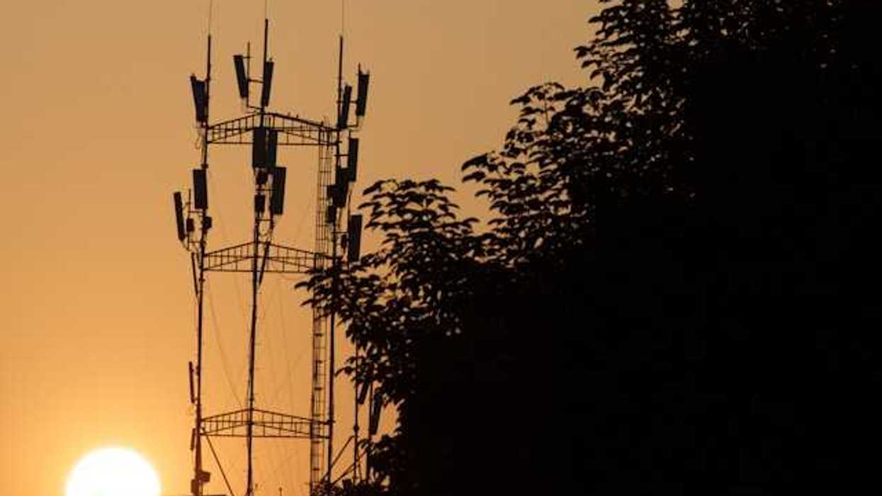 A broadcast tower with the setting sun in the background