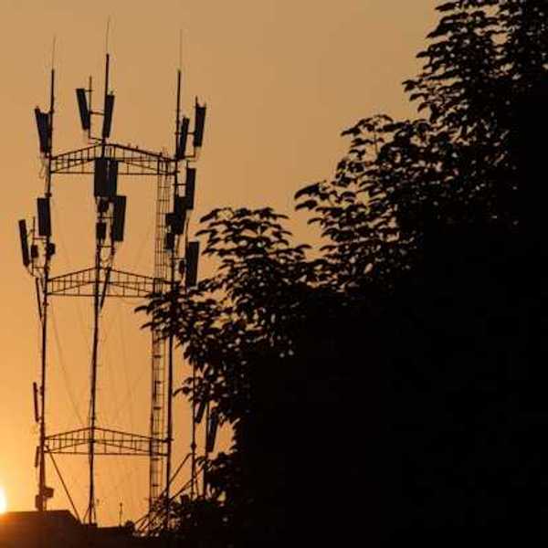 A broadcast tower with the setting sun in the background