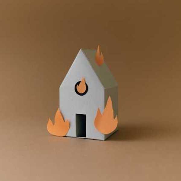 A cardboard model of a house with orange flames on the side