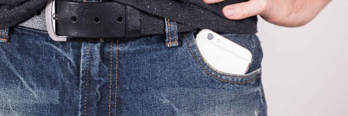A cell phone in a man's pants pockets