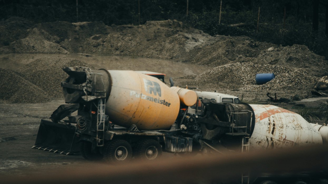 A cement mixer truck sits on a construction site.