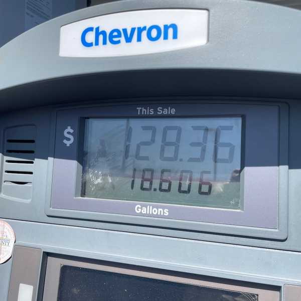 A Chevron gas pump showing a sale of $128.36 for 18.606 gallons
