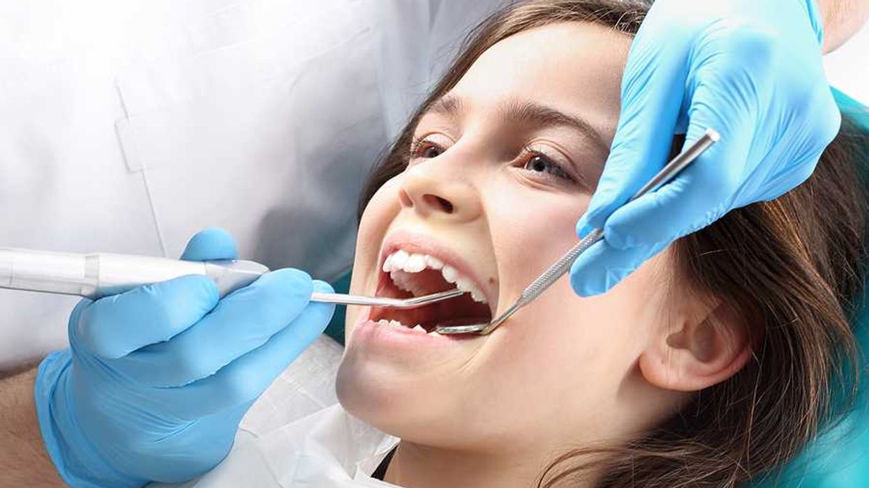 A child at the dentist having her teeth examined