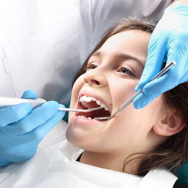 A child at the dentist having her teeth examined