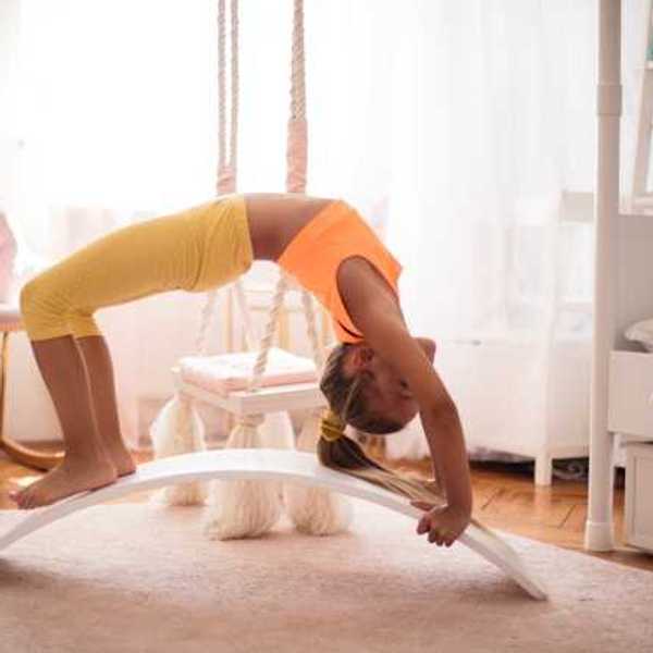 A child bending backward wearing leggings and a tank top