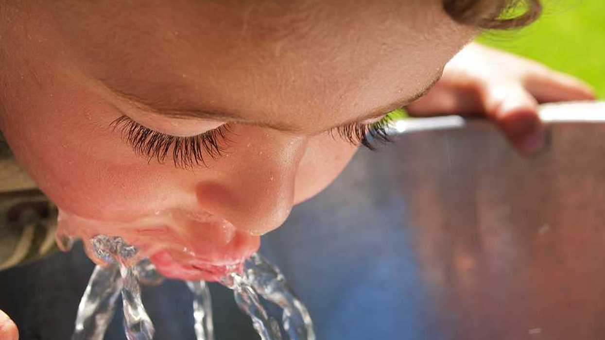 A child drinking water from a drinking fountain