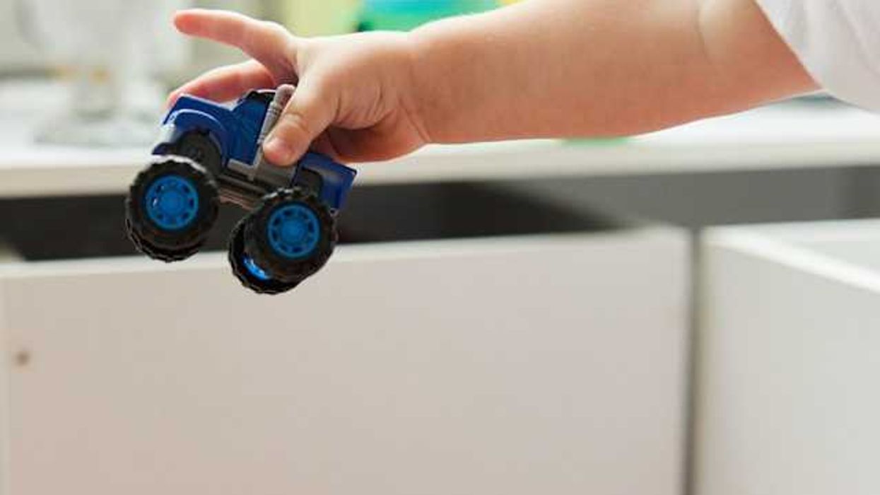 A child holding a plastic truck