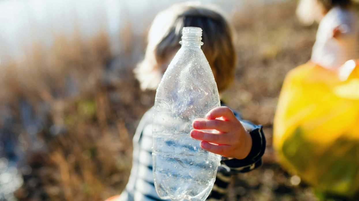 A child holds a used plastic bottle