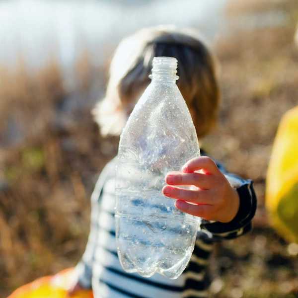 A child holds a used plastic bottle