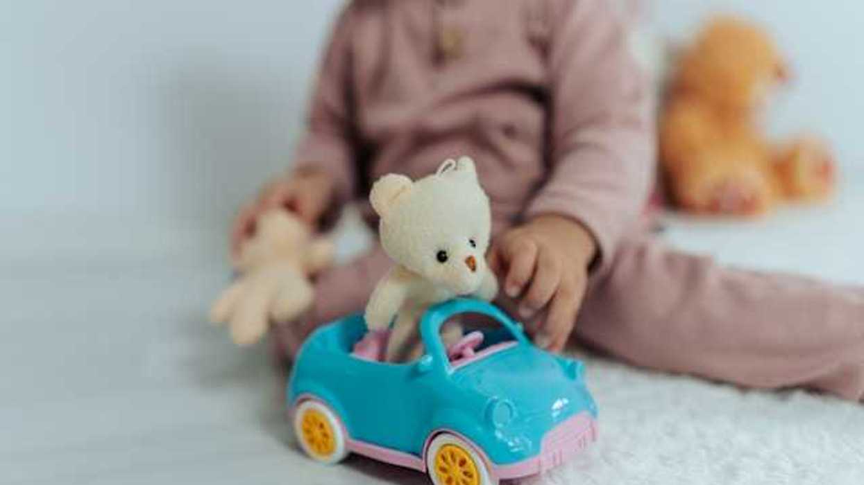 A child playing with a plastic car toy