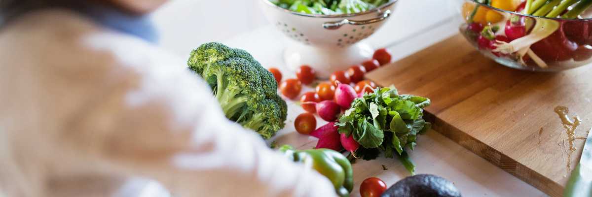 A child reaches for an assortment of vegetables