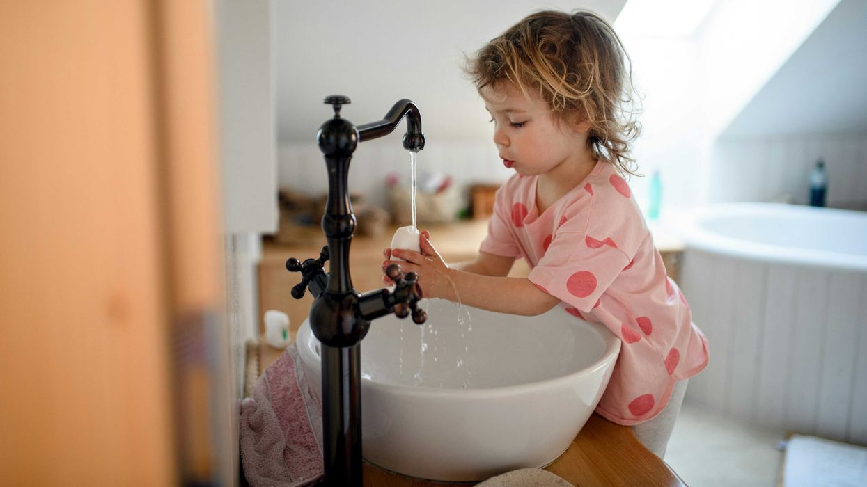 A child runs water out of a faucet