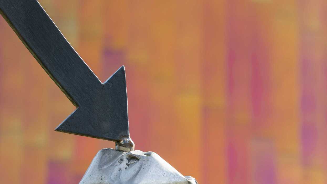 a close up of a metal object with an arrow pointing down on it against an orange and pink background.