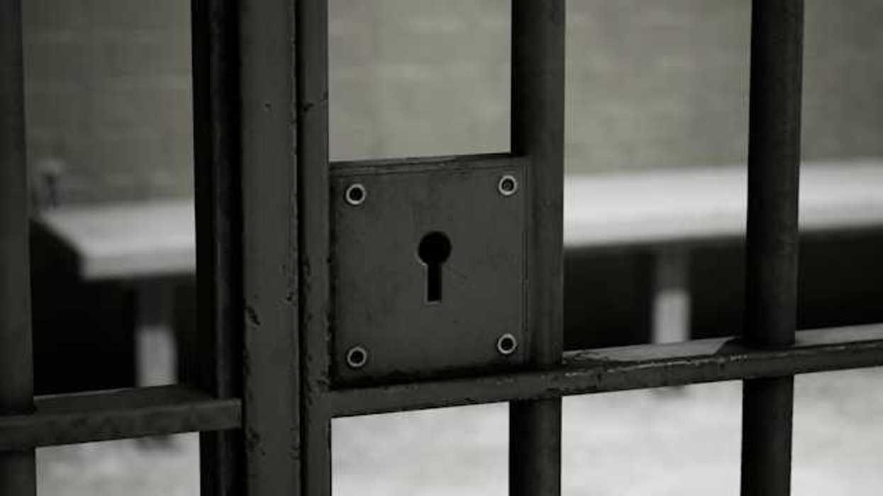 A closeup of a jail cell door with lock