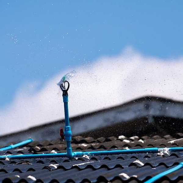 A closeup of a roof with a sprinkler system installed on it