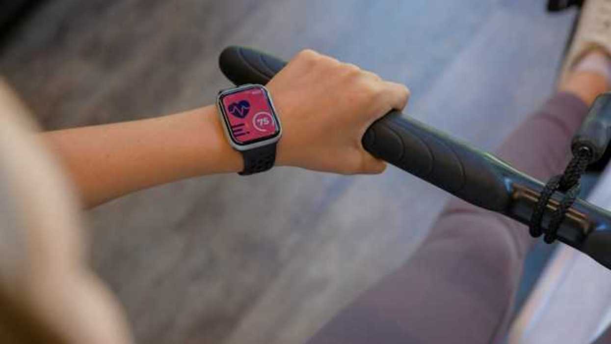 A closeup of a smartwatch on someone's arm on a stationary bike