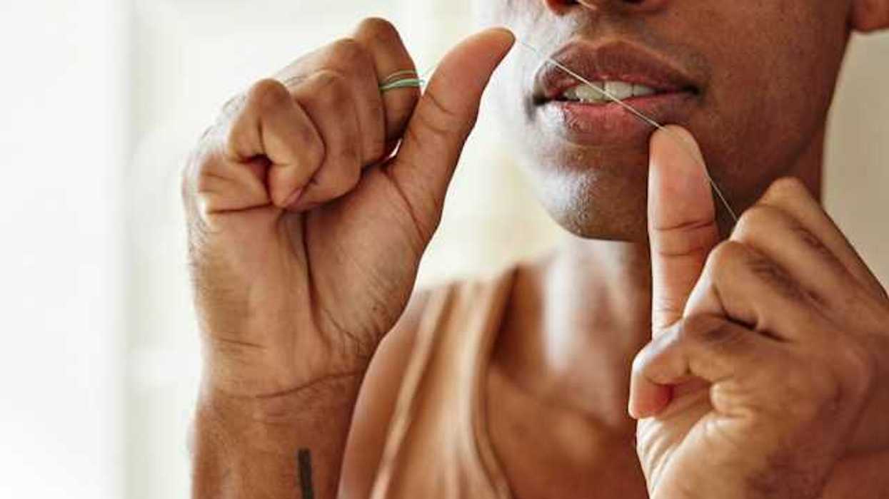 A closeup of a woman preparing to floss her teeth