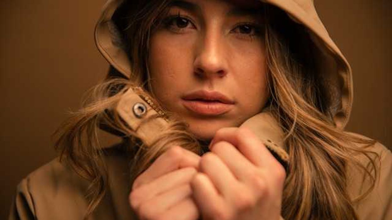 A closeup of a woman wearing a hooded waterproof jacket