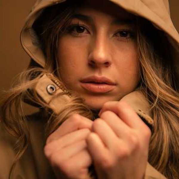 A closeup of a woman wearing a hooded waterproof jacket