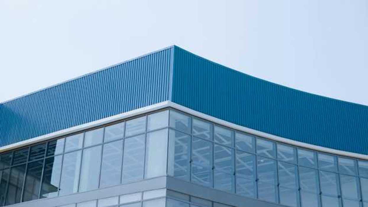 A closeup of the corner of a glass and metal building