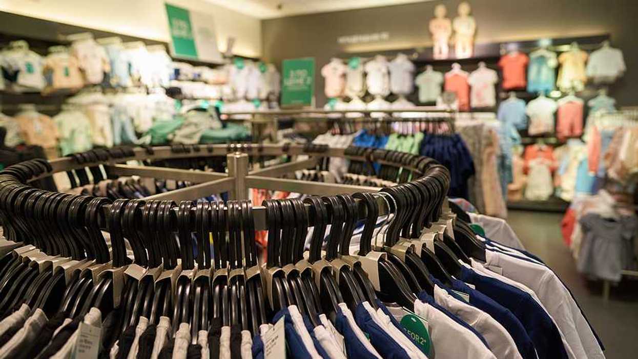 A clothing store with racks of multi-colored clothing